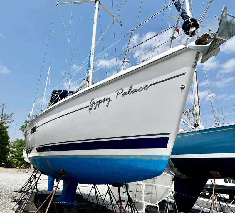 Slide: The Image of 2003 Hunter Passage 420 sailboat named "Gypsy Palace" on stands, clear sky background. - 2