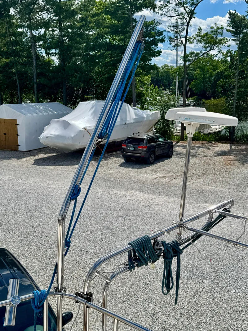 Slide: The Image of 2003 Hunter Passage 420 sailboat with rigging, parked in a marina with trees and vehicles. - 22
