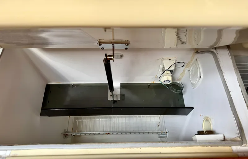 Slide: The Image of Interior view of a 2003 Hunter Passage 420 refrigerator with shelving and wiring. - 35