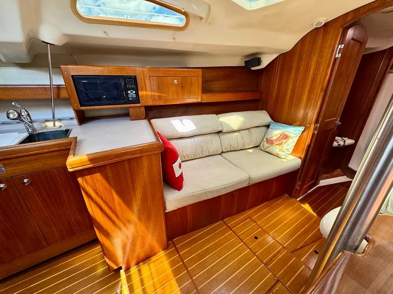 Slide: The Image of Interior of 2003 Hunter Passage 420 yacht with cozy seating and wooden cabinetry. - 37