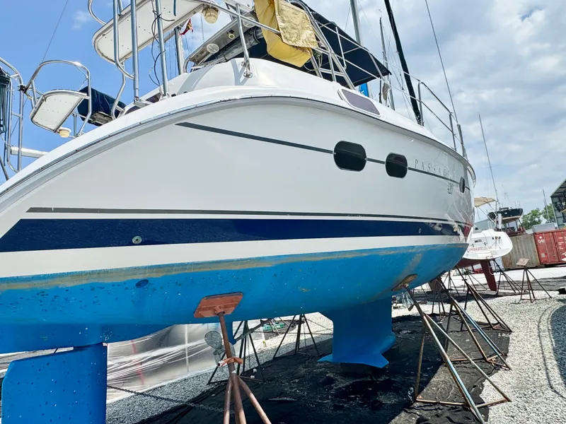 Slide: The Image of 2003 Hunter Passage 420 sailboat on stands, blue hull, marina setting. - 4