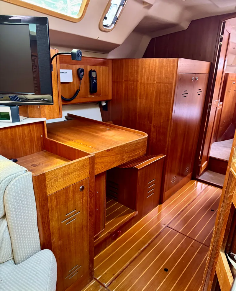 Slide: The Image of Interior of a 2003 Hunter Passage 420 sailboat with wooden cabinetry and seating area. - 49