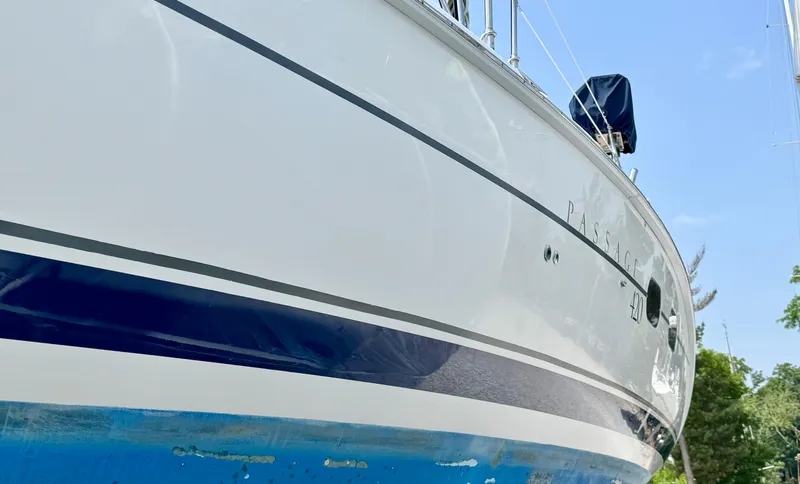 Slide: The Image of 2003 Hunter Passage 420 sailboat with blue and white hull, docked outdoors. - 5