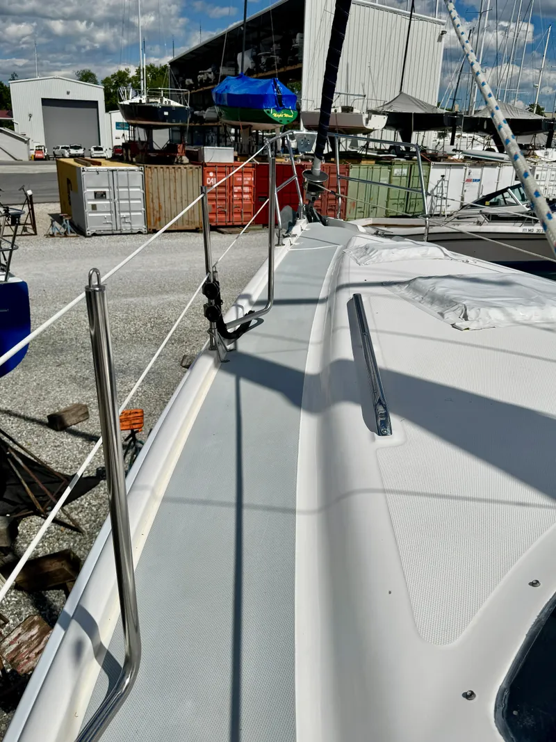 Slide: The Image of 2003 Hunter Passage 420 sailboat deck in a marina, showcasing sleek design and rigging. - 8