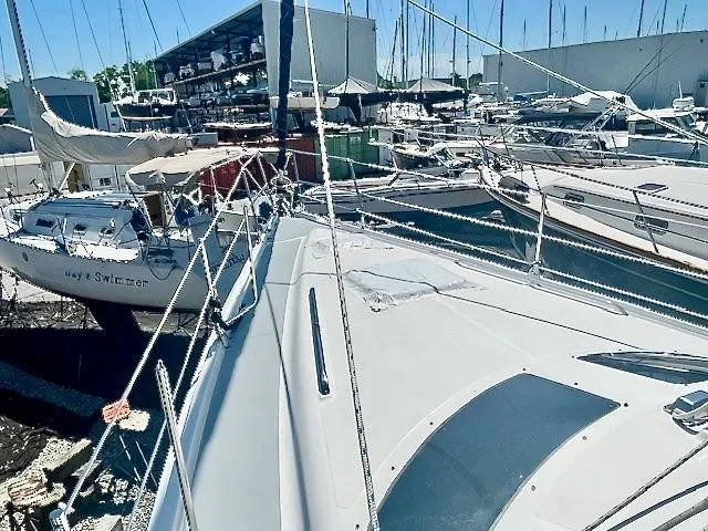 Slide: The Image of 2003 Hunter Passage 420 sailboat docked in a busy marina, surrounded by other vessels. - 9