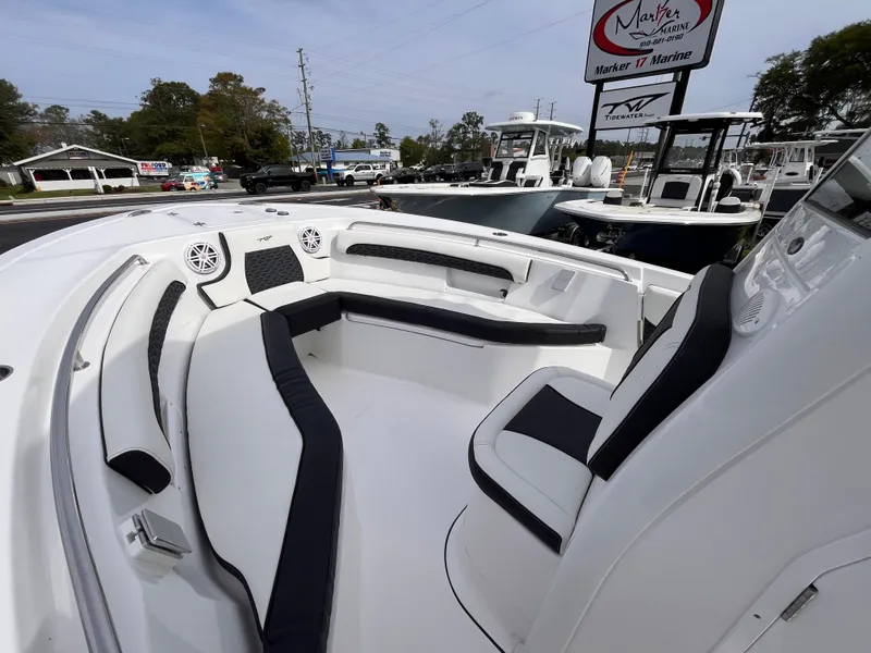Slide: The Image of 2025 Tidewater 232 LXF boat with spacious seating and modern design at a marina. - 12
