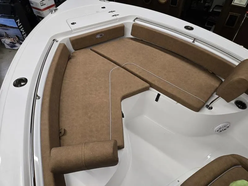 Slide: The Image of 2025 Sea Hunt Ultra 229 boat interior with tan cushioned seating and white deck. - 14