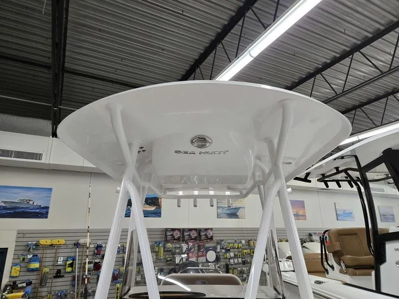 Slide: The Image of 2025 Sea Hunt Ultra 229 boat interior, showcasing sleek design and modern features in a showroom. - 17