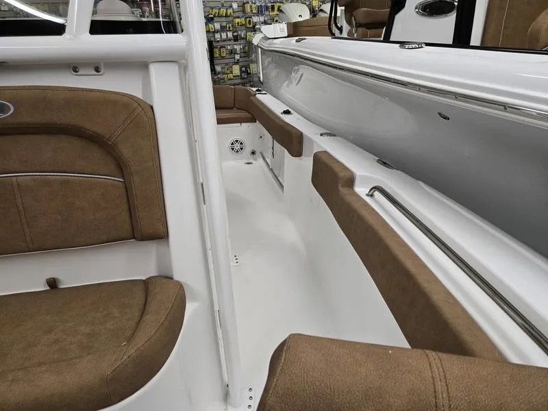 Slide: The Image of 2025 Sea Hunt Ultra 229 boat interior with brown seating and white deck. - 19