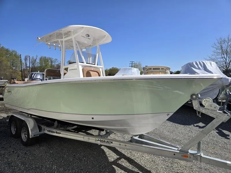 Slide: The Image of 2025 Sea Hunt Ultra 229 boat on trailer, light green hull, clear blue sky. - 4