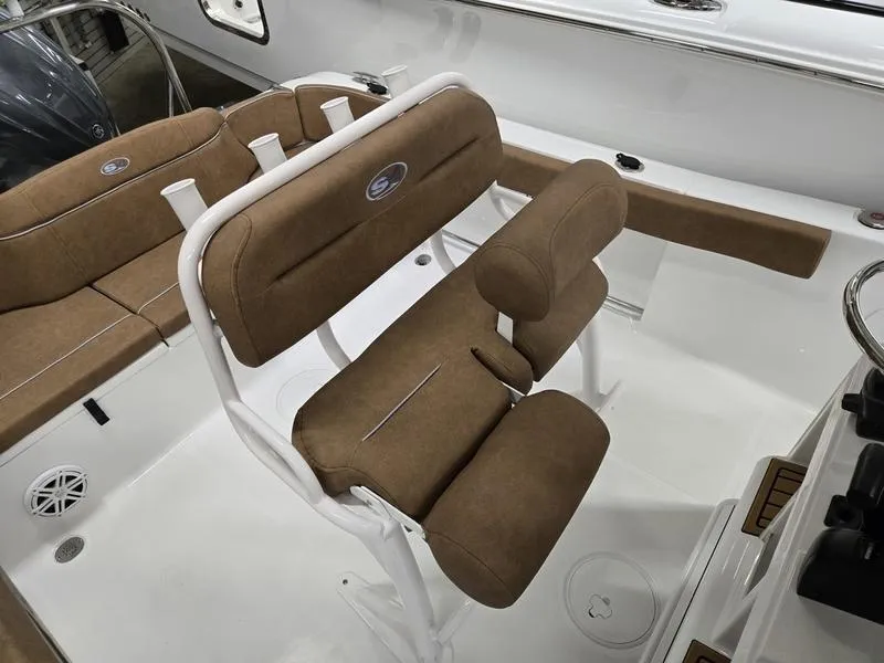 Slide: The Image of 2025 Sea Hunt Ultra 229 boat interior with brown cushioned seating and white framework. - 8