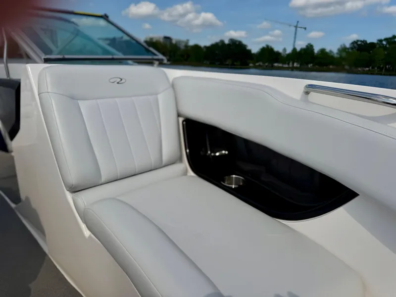 Slide: The Image of 2008 Regal 2200 Bowrider boat interior with white seating and cup holder, under blue sky. - 4