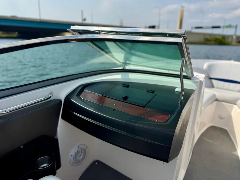 Slide: The Image of 2008 Regal 2200 Bowrider boat interior with windshield and dashboard, near water. - 7