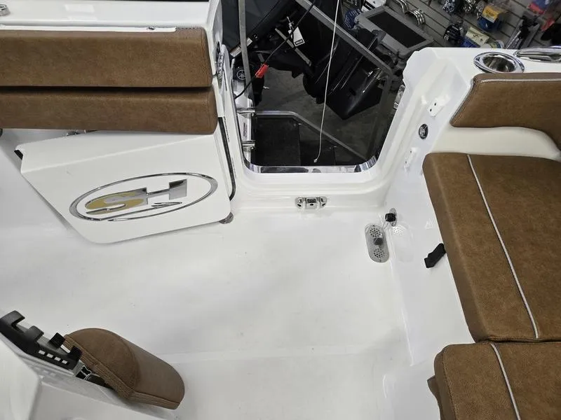 Slide: The Image of 2025 Sea Hunt Ultra 265SE boat interior with brown seating and white deck. - 11