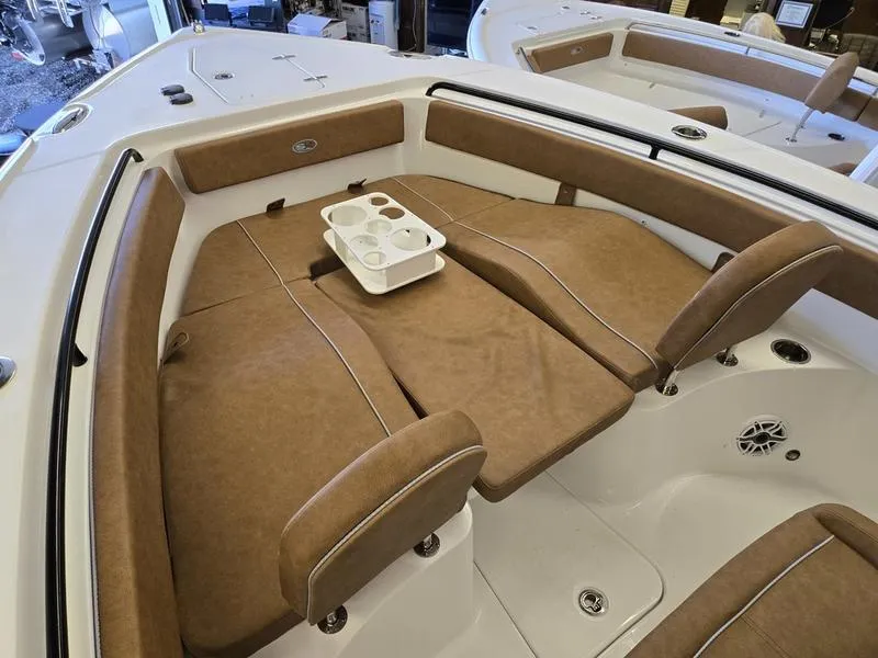 Slide: The Image of 2025 Sea Hunt Ultra 265SE boat interior with brown cushioned seating and cup holders. - 14