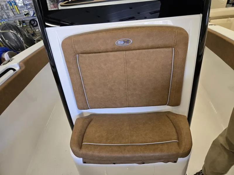 Slide: The Image of 2025 Sea Hunt Ultra 265SE boat seat with brown upholstery and white trim. - 15