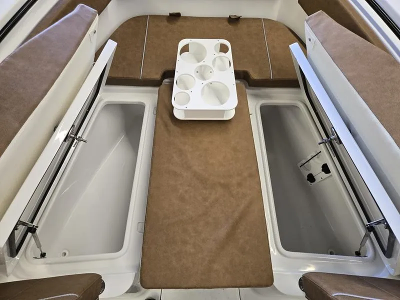 Slide: The Image of 2025 Sea Hunt Ultra 265SE boat interior with brown seating and storage compartments. - 16