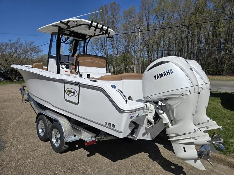 Slide: The Image of 2025 Sea Hunt Ultra 265SE boat with Yamaha engines on a trailer, parked outdoors. - 5