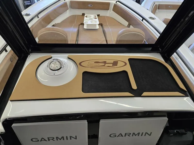 Slide: The Image of 2025 Sea Hunt Ultra 265SE boat interior with Garmin electronics and compass. - 8