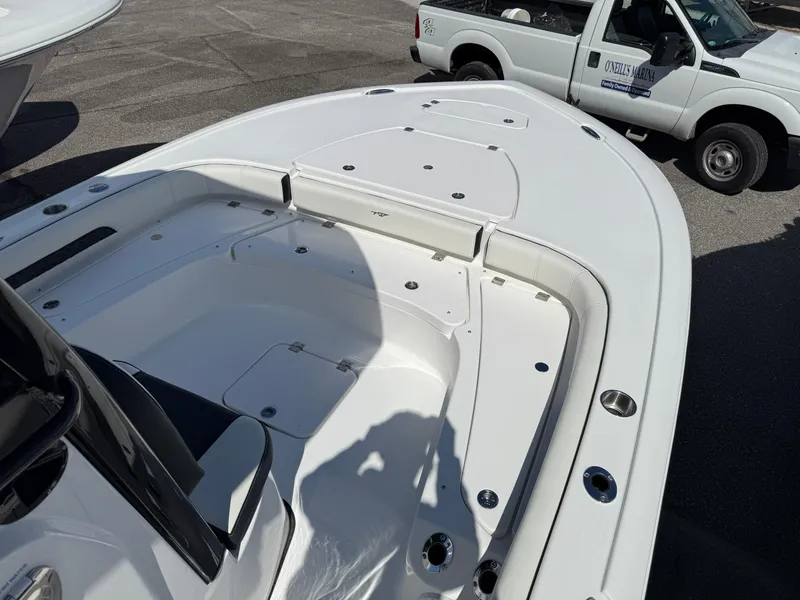 Slide: The Image of 2025 Tidewater 2500 Carolina Bay boat, white deck, parked near a white truck. - 1