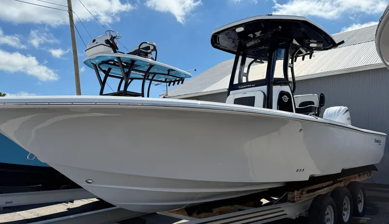 Slide: The Image of 2025 Tidewater 2500 Carolina Bay boat on trailer, displayed outdoors. - 5