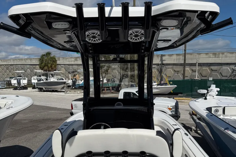 Slide: The Image of 2025 Tidewater 2500 Carolina Bay boat with T-top and rod holders, docked in a marina. - 7