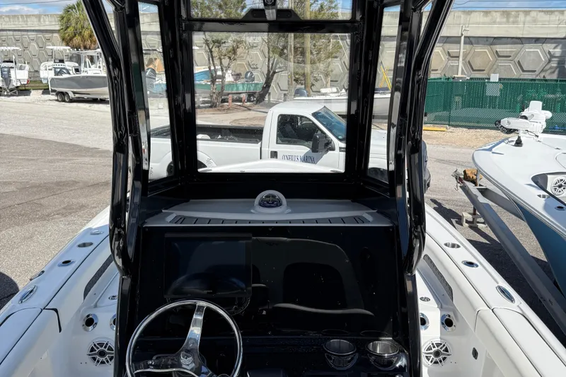 Slide: The Image of 2025 Tidewater 2500 Carolina Bay boat dashboard with steering wheel and controls. - 8