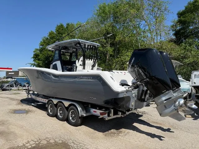 Slide: The Image of 2025 Tidewater 320 CC Adventure boat on trailer, featuring sleek design and powerful outboard engines. - 1