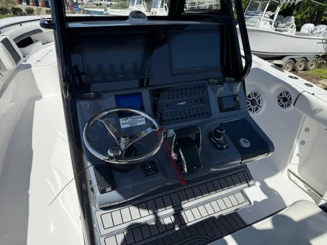 Slide: The Image of 2025 Tidewater 320 CC Adventure boat dashboard with steering wheel and control panel. - 10