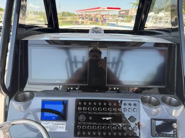 Slide: The Image of 2025 Tidewater 320 CC Adventure boat dashboard with dual screens and control panel. - 12