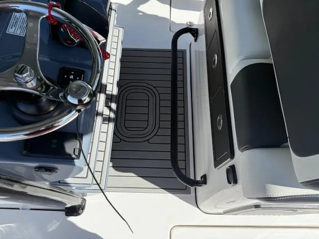 Slide: The Image of 2025 Tidewater 320 CC Adventure boat cockpit with steering wheel and seating area. - 15