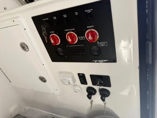 Slide: The Image of Control panel of 2025 Tidewater 320 CC Adventure boat with switches and keys. - 22
