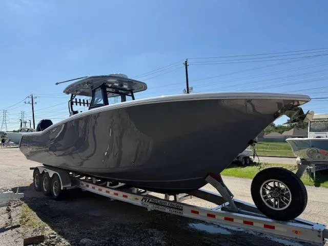 Slide: The Image of 2025 Tidewater 320 CC Adventure boat on a trailer under clear blue sky. - 3