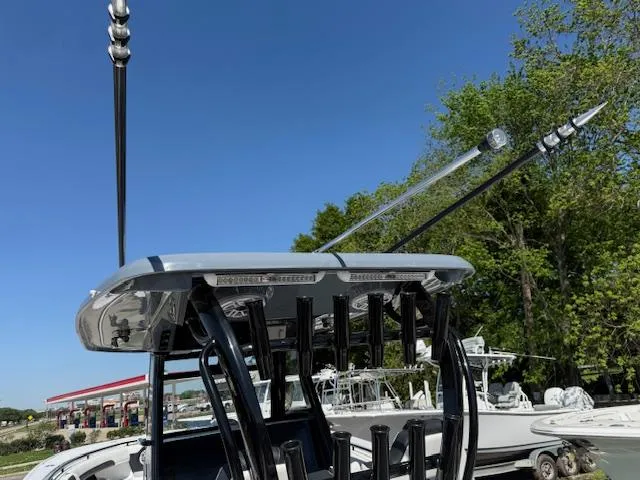 Slide: The Image of 2025 Tidewater 320 CC Adventure boat with fishing rod holders and antennas, under clear blue sky. - 5