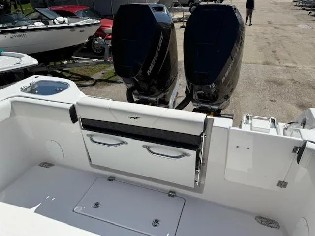 Slide: The Image of 2025 Tidewater 320 CC Adventure boat with dual Mercury outboard engines, docked outdoors. - 6