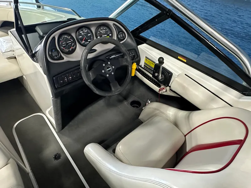 Slide: The Image of 2002 Malibu Sunsetter boat interior with steering wheel and dashboard, overlooking water. - 10