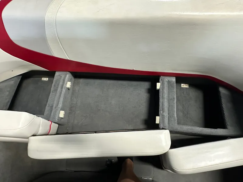 Slide: The Image of 2002 Malibu Sunsetter boat interior with open storage compartments and white-red seating. - 15