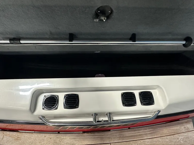 Slide: The Image of 2002 Malibu Sunsetter boat storage compartment with ventilation grilles and handle. - 16