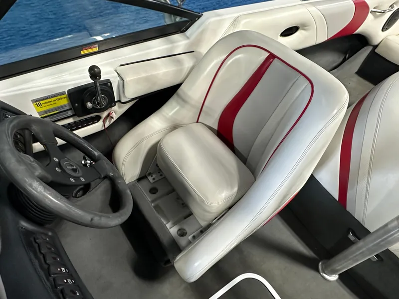 Slide: The Image of 2002 Malibu Sunsetter boat interior with steering wheel and white-red seating. - 8
