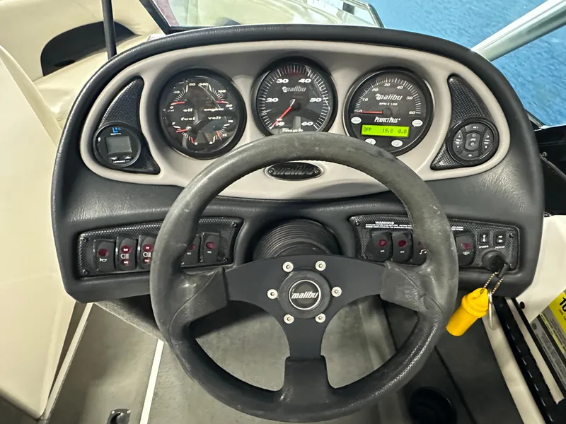 Slide: The Image of 2002 Malibu Sunsetter boat dashboard with steering wheel and instrument panel. - 9