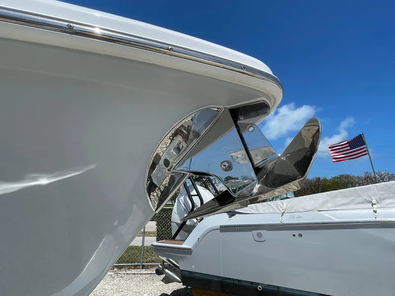 Slide: The Image of 2025 Everglades 273CC boat on trailer, clear sky, American flags in background. - 2