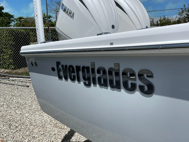 Slide: The Image of 2025 Everglades 273CC boat with Yamaha engine, parked on gravel. - 24