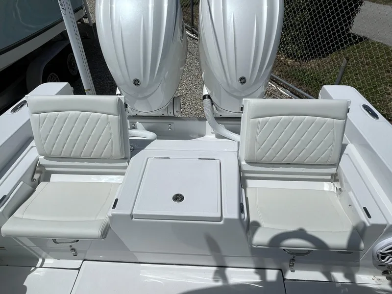 Slide: The Image of 2025 Everglades 273CC boat interior with white cushioned seating and dual outboard motors. - 7