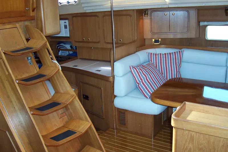Slide: The Image of Interior of 1994 C&C 51 XL C/B yacht with wooden cabinetry and cozy seating area. - 11