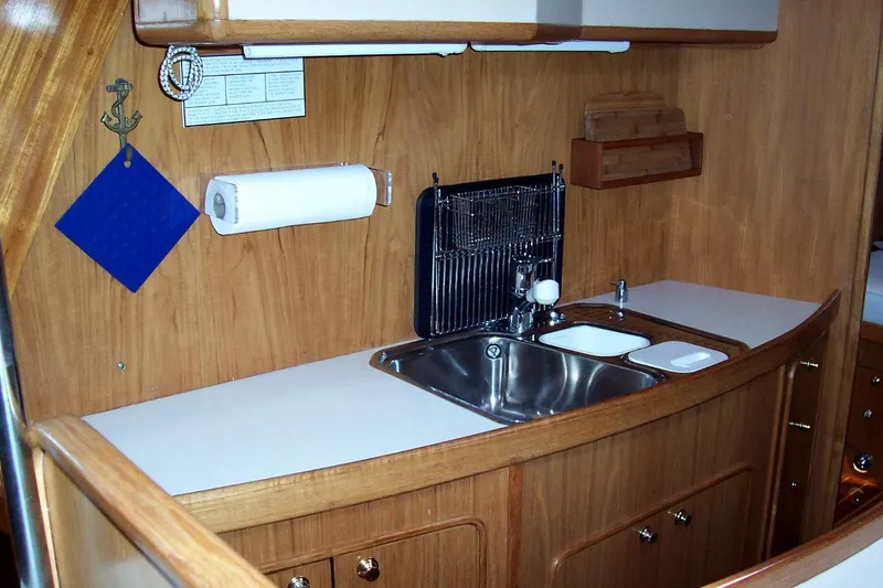 Slide: The Image of 1994 C&C 51 XL C/B yacht kitchen with wooden cabinetry and stainless steel sink. - 20
