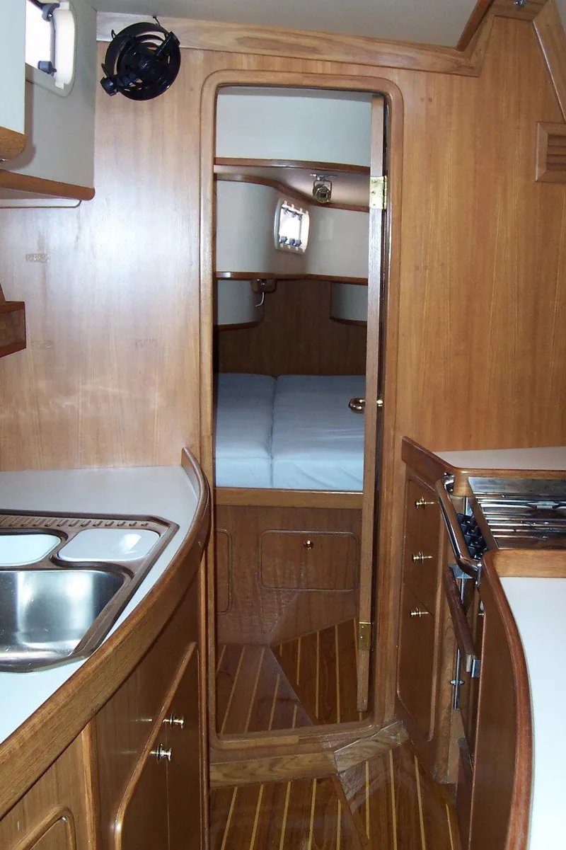 Slide: The Image of Interior of 1994 C&C 51 XL C/B yacht with wooden cabinetry and compact kitchen. - 22