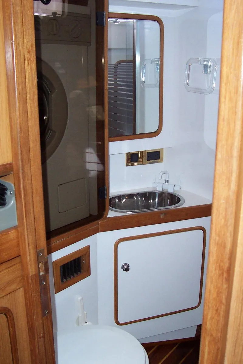Slide: The Image of Compact bathroom in a 1994 C&C 51 XL C/B yacht with wooden accents and stainless steel sink. - 26