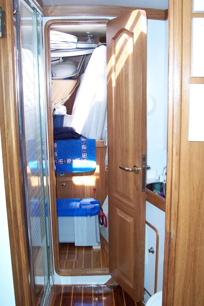 Slide: The Image of Interior of 1994 C&C 51 XL C/B sailboat with wooden cabinetry and compact storage. - 29