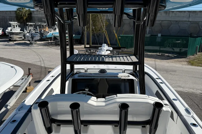 Slide: The Image of 2025 Tidewater 2700 Carolina Bay boat with rod holders and T-top in a marina setting. - 10