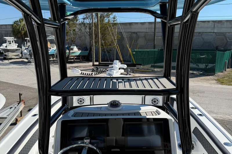 Slide: The Image of 2025 Tidewater 2700 Carolina Bay boat with T-top and electronics, docked outdoors. - 11